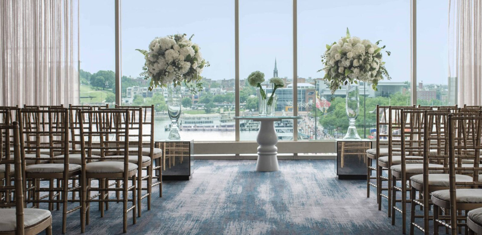Wedding, seating and aisle with view of harbor at Renaissance Baltimore Harborplace Hotel