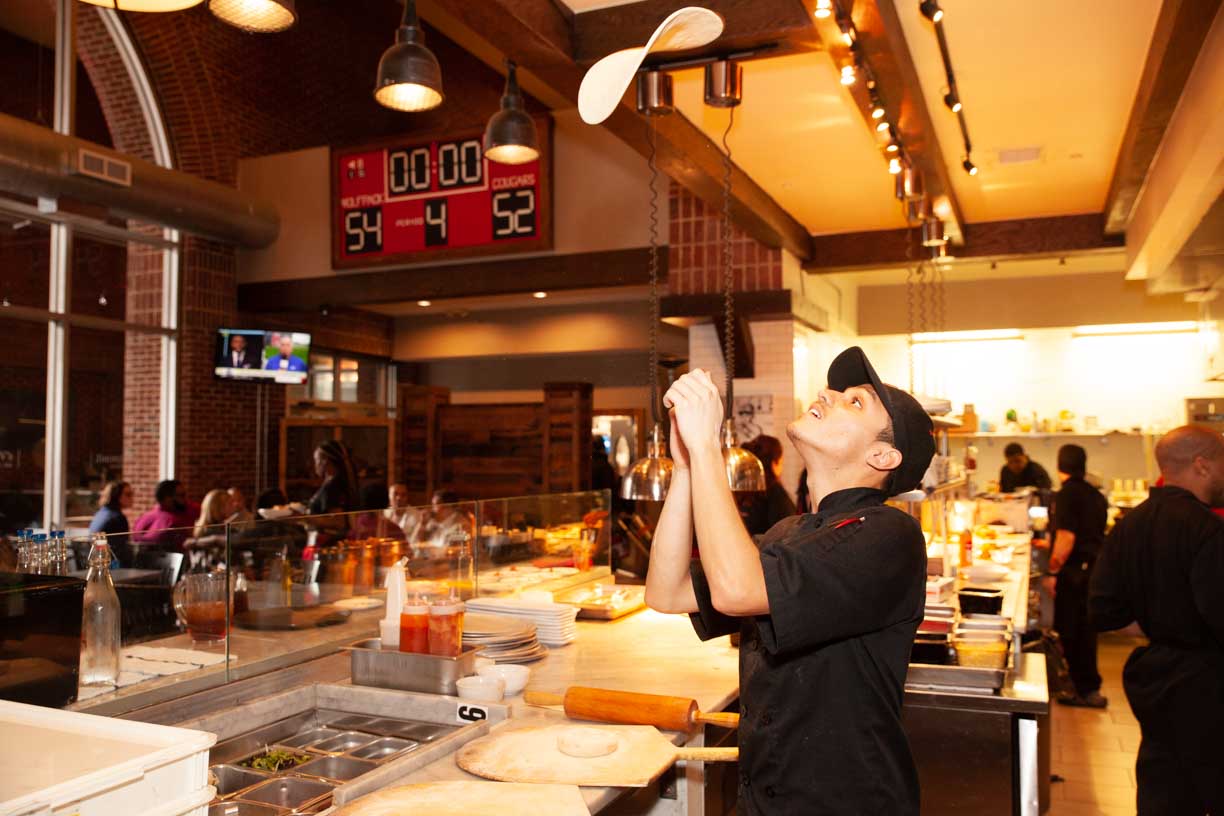 Worker tossing pizza dough at Jimmy V's at Sheraton Raleigh