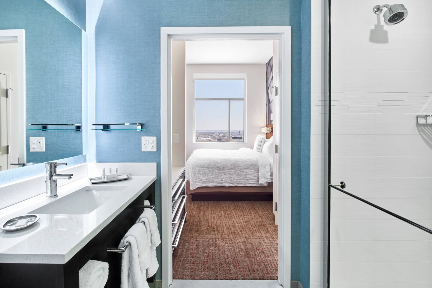 Bathroom with blue walls and bed with view of downtown at Residence Inn Wilmington Downtown Hotel
